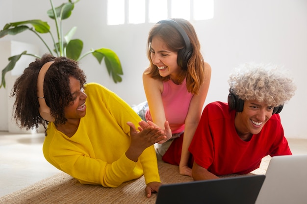 A diverse group of people are participating in an online course on their devices (laptops, tablets, and phones), each person is actively engaged, with varying backgrounds and locations.