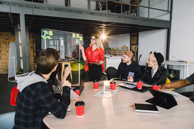 A person enthusiastically presenting a project in a modern office setting, surrounded by colleagues. The scene is dynamic and showcases the practical application of skills learned through online courses.