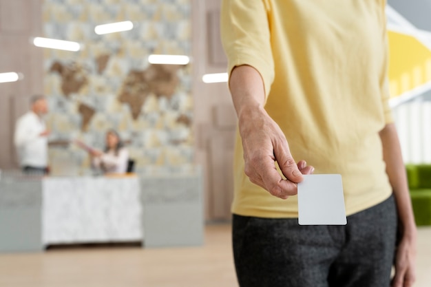 A split image showing different health insurance cards (HMO, PPO, HDHP) side by side, against a background of a doctor's office waiting area.