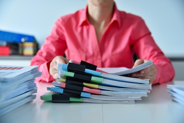 A person filing receipts and documents into labeled folders, illustrating the organization needed to track business expenses for tax deductions.