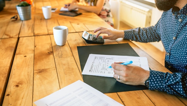 A person carefully filling out a direct deposit form, emphasizing the importance of accuracy and caution when providing bank details to an employer