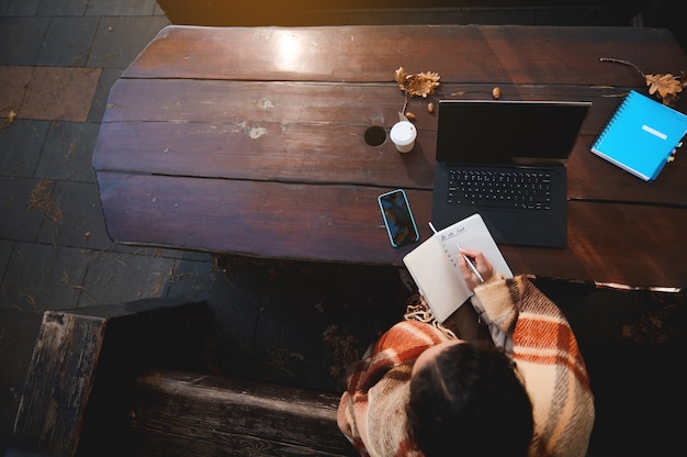 A person sitting at a desk, reviewing a secret shopping report on a laptop. They are highlighting key observations and preparing to submit the report online.