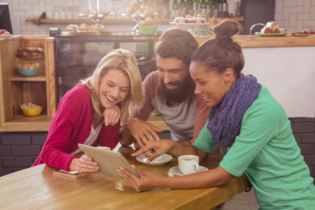A family happily gathered around a table, reviewing energy-saving tips on a tablet. The screen displays various energy-efficient appliances and home improvement options, symbolizing a collaborative approach .