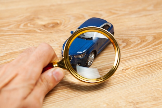 A person reviewing a car insurance policy document with a magnifying glass, highlighting the fine print and details.