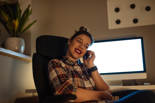 A person relaxing on a couch, watching a movie on a smart TV. The TV screen displays a film streaming from a library service.