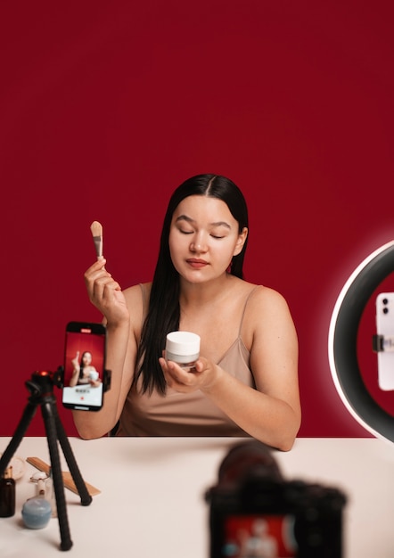 A smartphone displaying an Instagram post from a beauty influencer holding up several free sample products. The post mentions a collaboration with a beauty brand and includes instructions on how followers can enter a giveaway to win free samples.