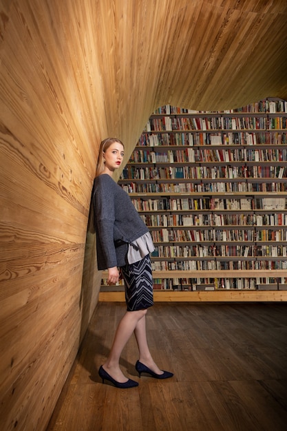 A split image, with one side showing a person browsing shelves in a traditional library and the other side showing a person using a tablet to access an ebook from a digital library. The image emphasizes the contrast and similarities between the two types of libraries.