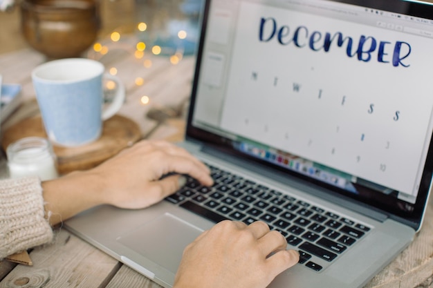 A person searching for free 2025 wall calendars on a laptop. The screen shows a freebie website with multiple calendar offers listed.