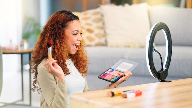 An influencer demonstrating beauty products in a well-lit studio. The set includes various makeup items, skincare products, and professional lighting equipment, such as ring lights. The influencer is applying makeup while speaking to the camera, exemplifying a typical beauty tutorial setting.