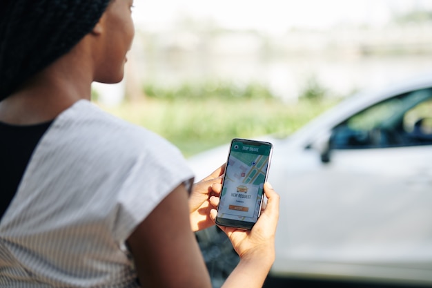 An image showing a person using a mobile app to track mileage in their car, highlighting the ease of digital mileage tracking for accurate reimbursement claims.