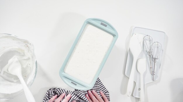 A close-up of a welcome kit from a baby club, showcasing sample-sized items like baby lotion, diaper cream, and a small pack of diapers, placed against a soft, pastel-colored background.