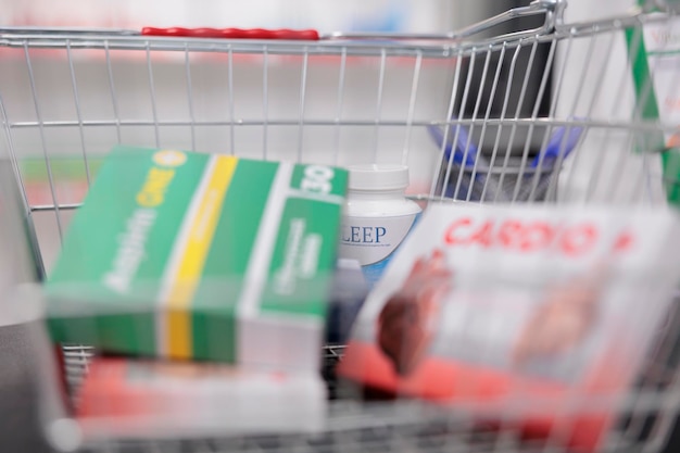 A shopping cart filled with various products purchased from Walmart. Several items have rollback stickers on them. The background shows a blurred aisle of the Walmart store.