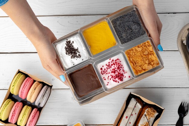 A close-up shot of a hand opening a free food sample box at home, displaying different snack and ingredient packs. Focus on showing the variety of samples and their convenience.