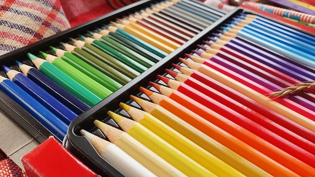A close-up shot of colorful pens, pencils, and markers arranged neatly in a pencil case. The focus is on the vibrant colors and the quality of the writing instruments, emphasizing the variety and value offered at Staples.